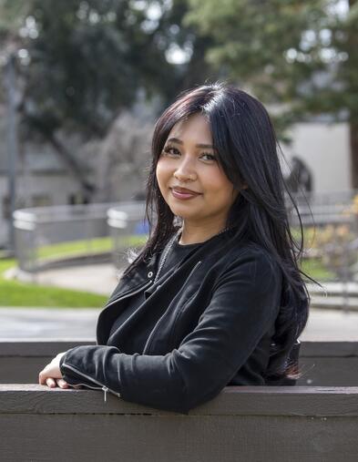 Student leaning near bridge and smiling