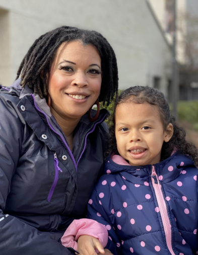 Portrait of mom and young daughter outside wearing jackets and smiling