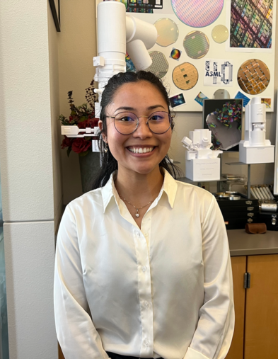 Student standing and smiling in front of Electron Microscopy information