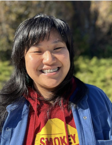 Portrait of student smiling with greenery in the background