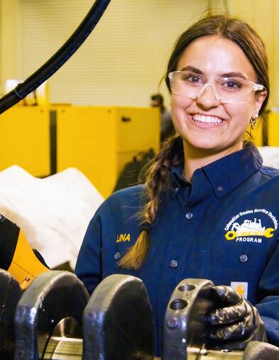 Student standing with Diesel and Heavy Equipment smiling