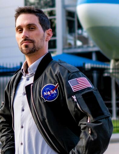 Man standing proudly wearing a NASA jacket