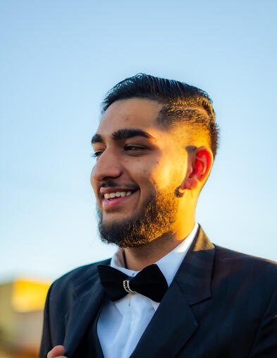 Delta College student, smiling outdoors while wearing a black suit and bow tie.